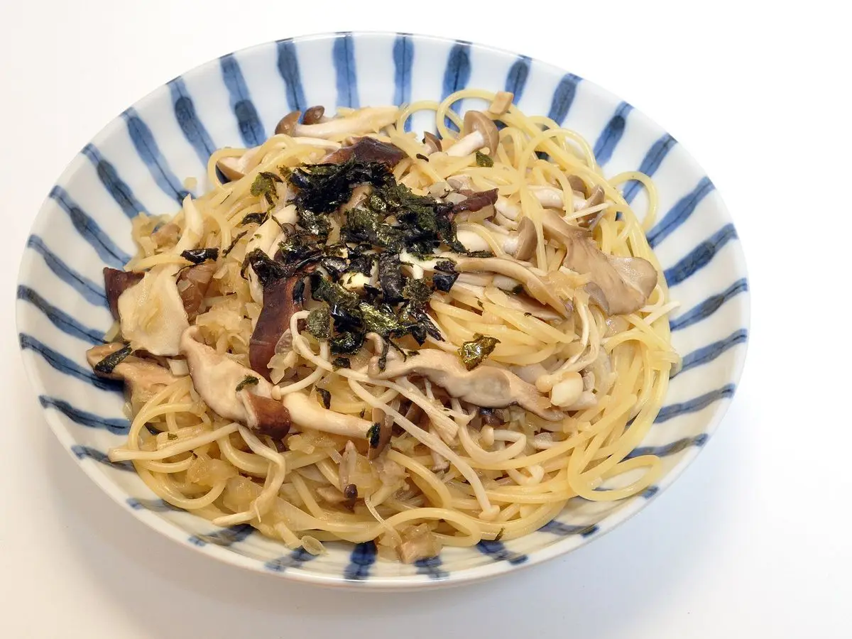 Cuenco de espaguetis con setas y alga nori desmenuzada por encima