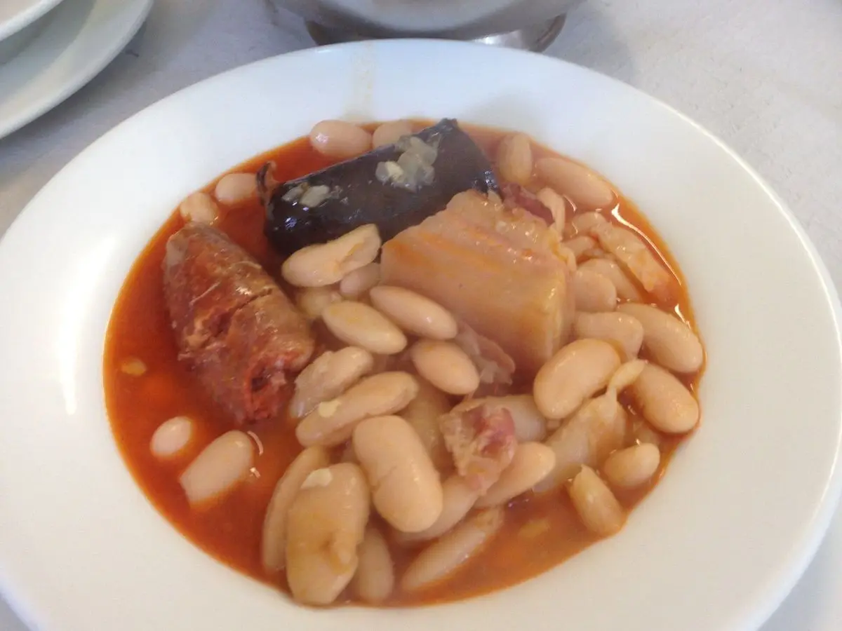 Plato hondo con fabes, chorizo, morcilla y tocino en caldo rojizo