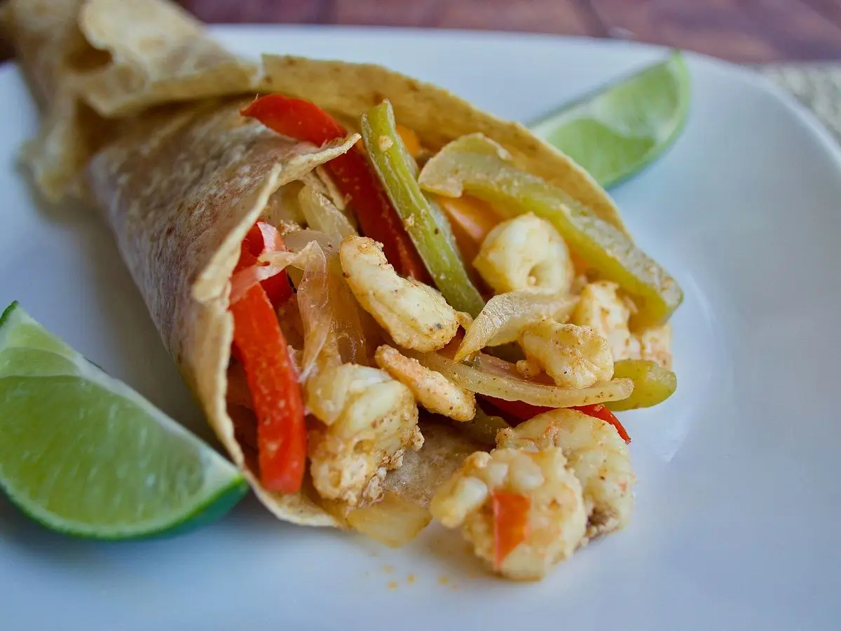 Tortilla de trigo rellena de gambas y tiras de pimiento rojo y verde con lima