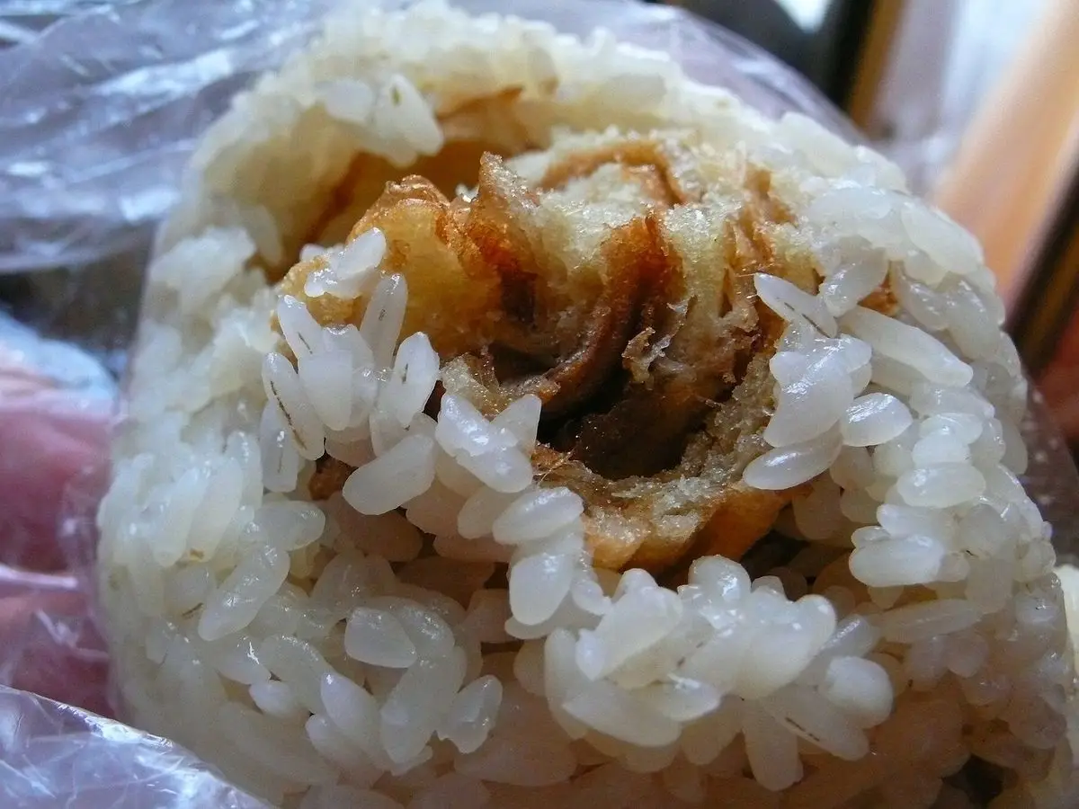 Rollo de arroz glutinoso taiwanés abierto por la mitad, con relleno salado visible