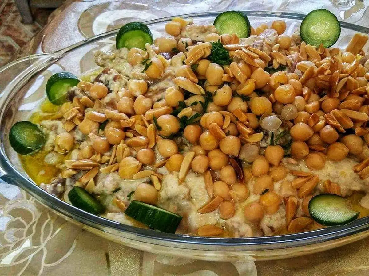 Fuente de cristal con garbanzos, pan tostado crujiente y rodajas de pepino