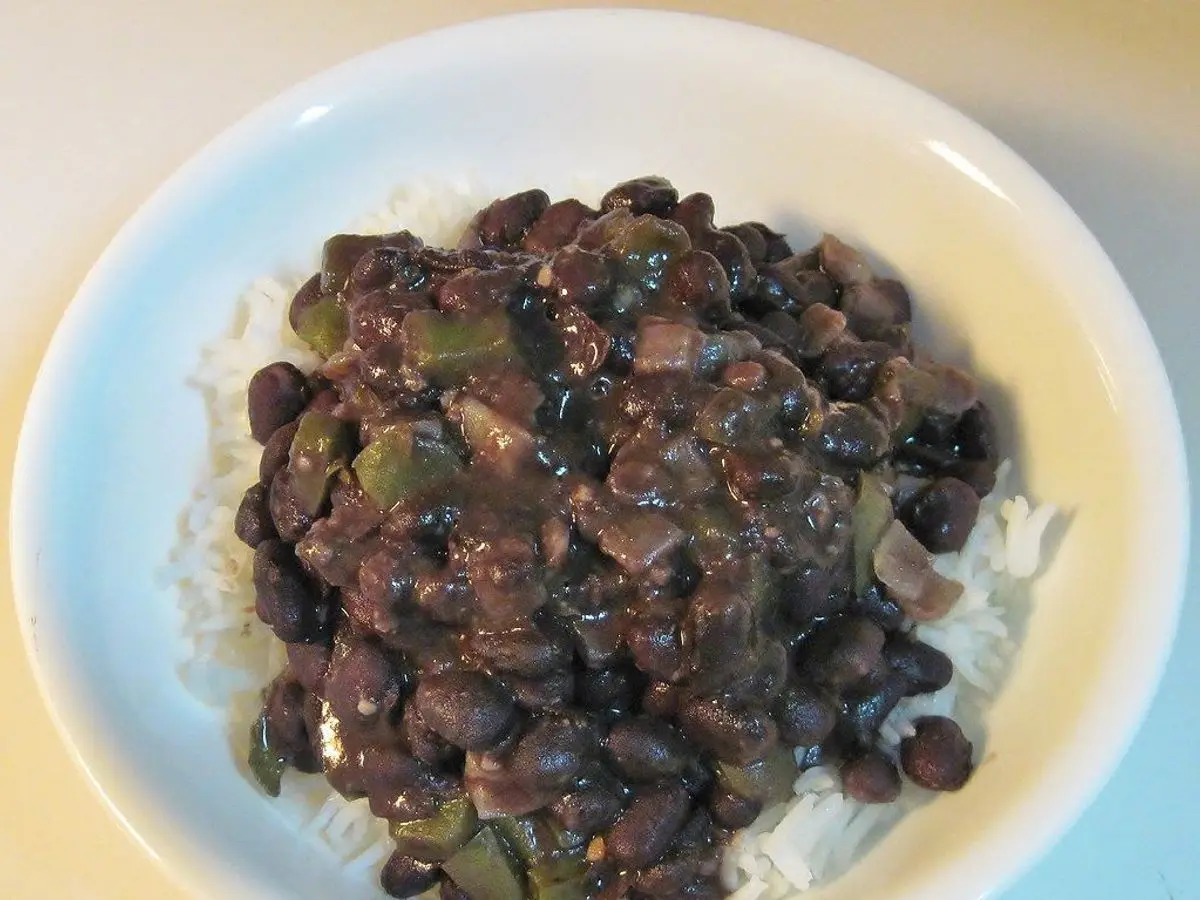 Plato de alubias negras guisadas con pimiento sobre arroz blanco