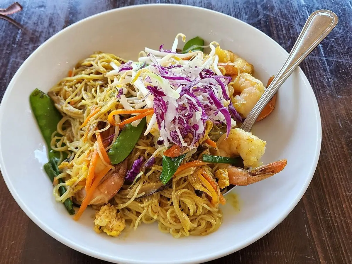 Cuenco de fideos finos salteados con verduras, col lombarda, guisantes y gambas