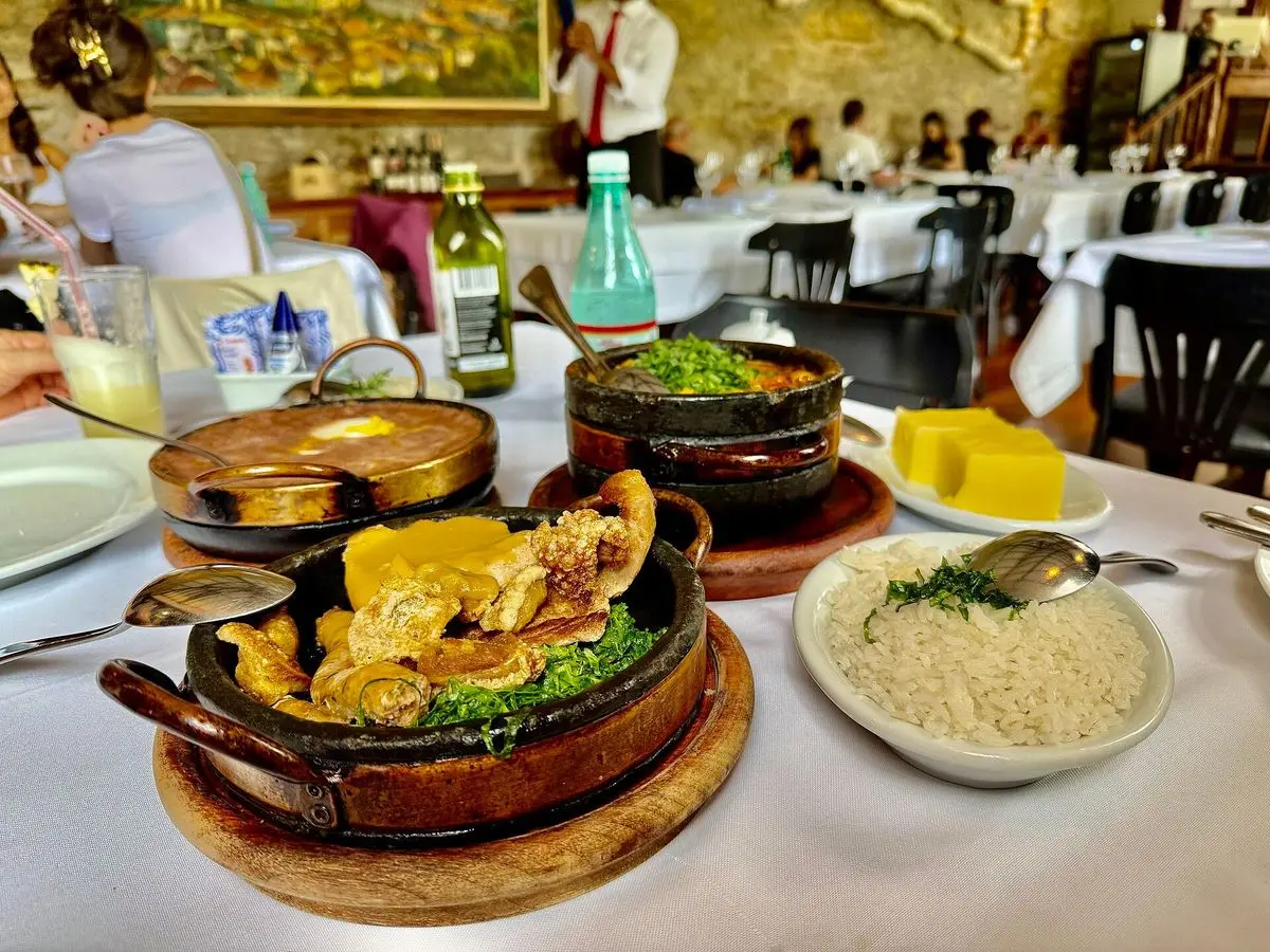 Almuerzo mineiro con cazuela de pollo guisado en barro, arroz blanco, verdura salteada y polenta
