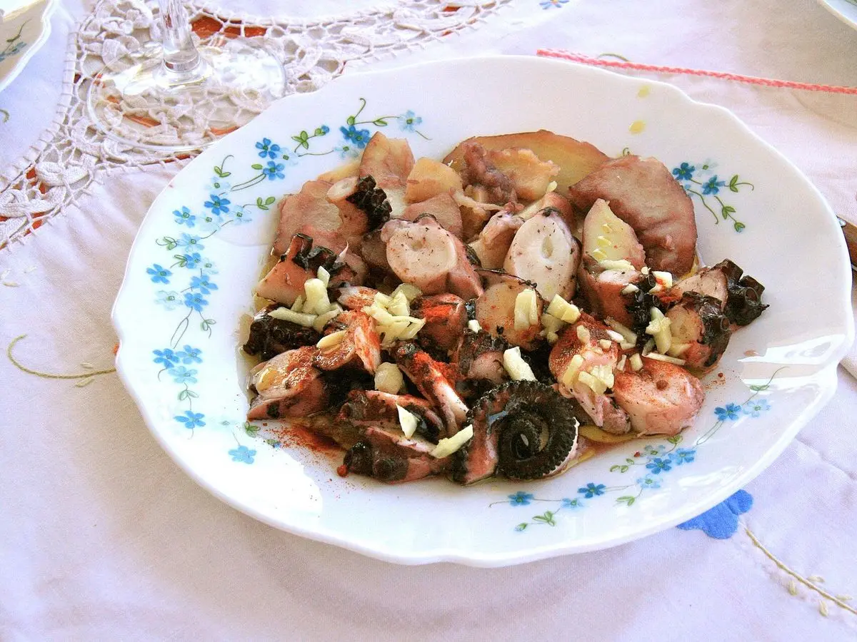 Plato de pulpo troceado salteado con patatas, ajo y perejil