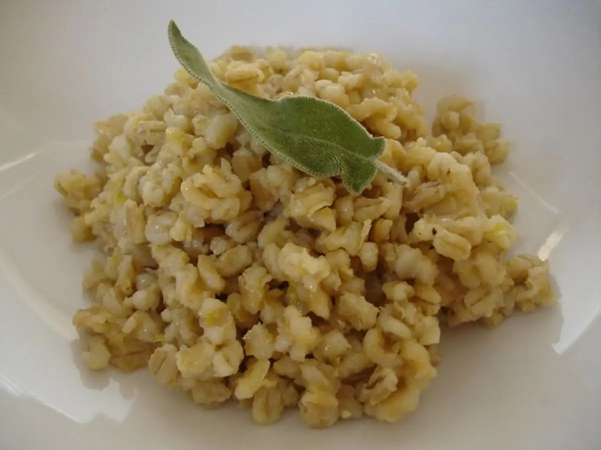 Plato de cebada perlada cocida con una hoja de laurel por encima