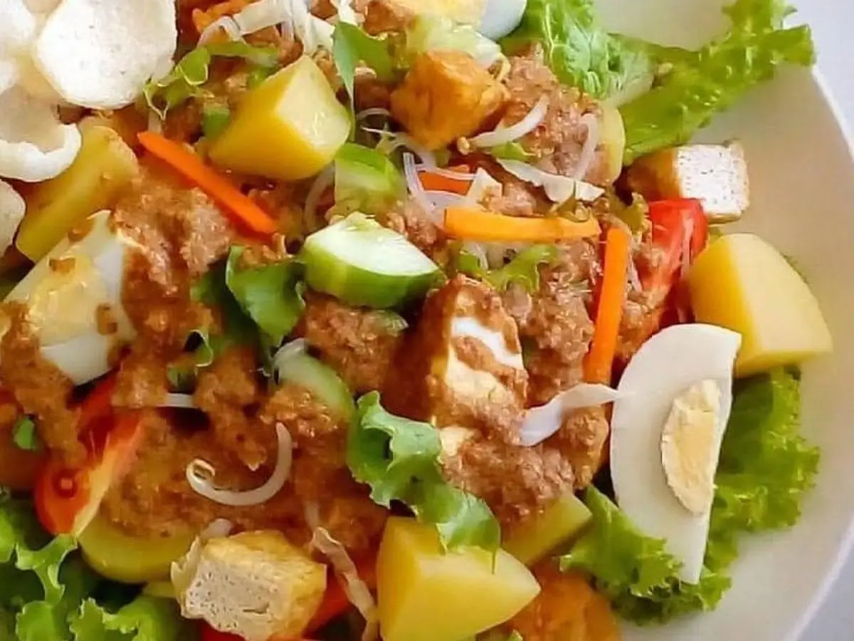 Ensalada gado-gado con tofu, patata, huevo duro, verduras y crujientes de gambas sobre lechuga