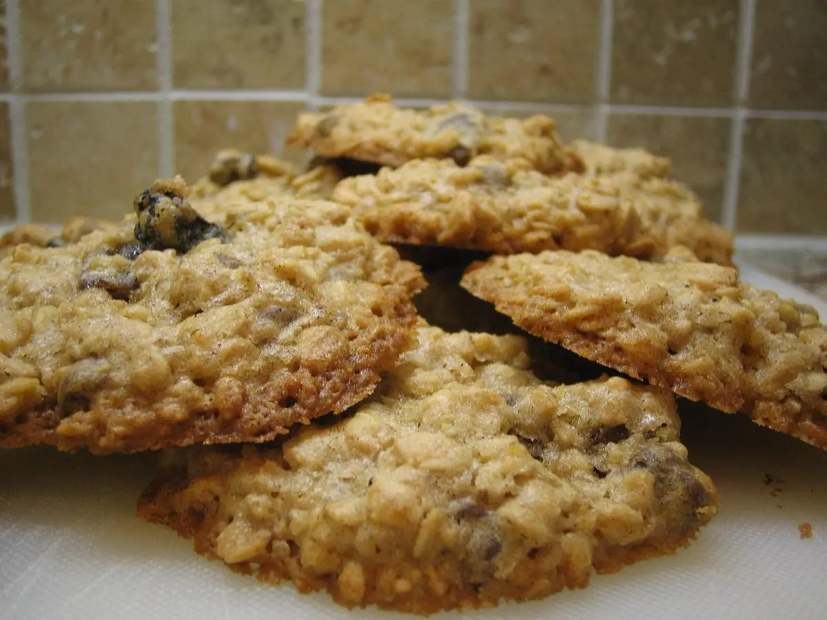 Pila de galletas de avena con pasas sobre una superficie de cocina con azulejos