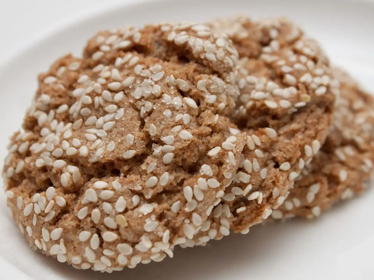 Galletas redondas cubiertas de semillas de sésamo sobre un plato blanco