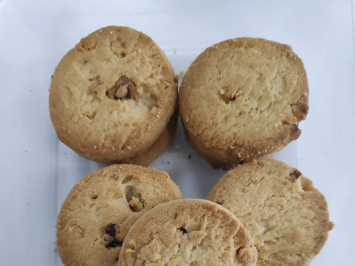 Galletas redondas de avellana de color dorado apiladas sobre un fondo claro