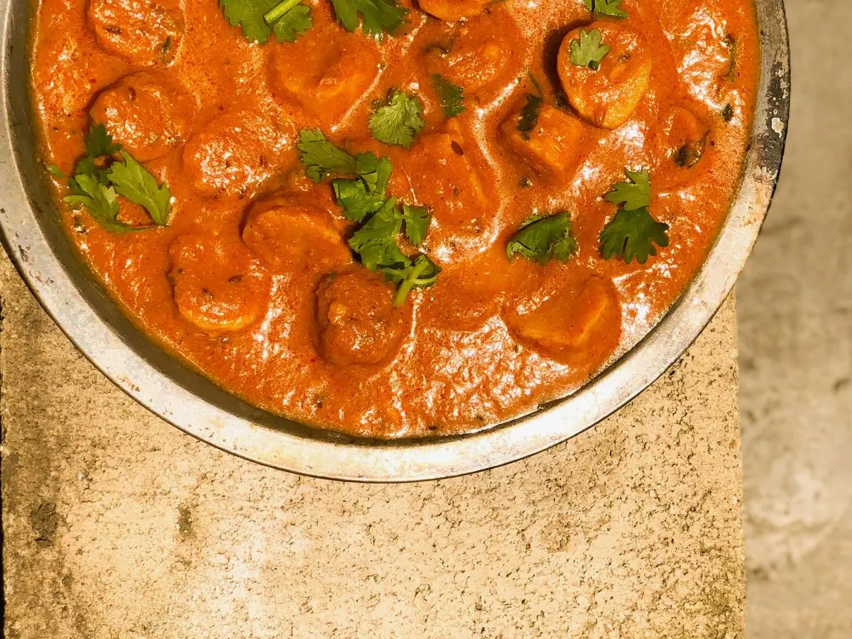Fuente de curry naranja con albóndigas de harina de garbanzo y cilantro