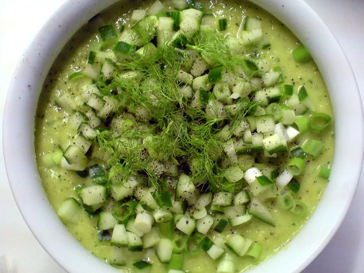 Cuenco de gazpacho verde cubierto de dados de pepino y eneldo picado