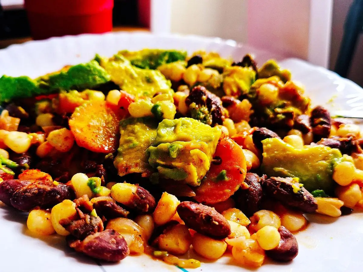 Plato blanco de githeri con maíz, alubias rojas, tomate y aguacate