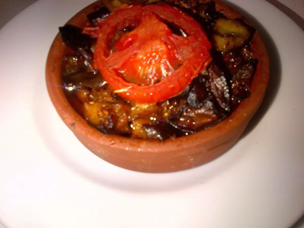 Cazuelita de barro con berenjena asada y una rodaja de tomate encima