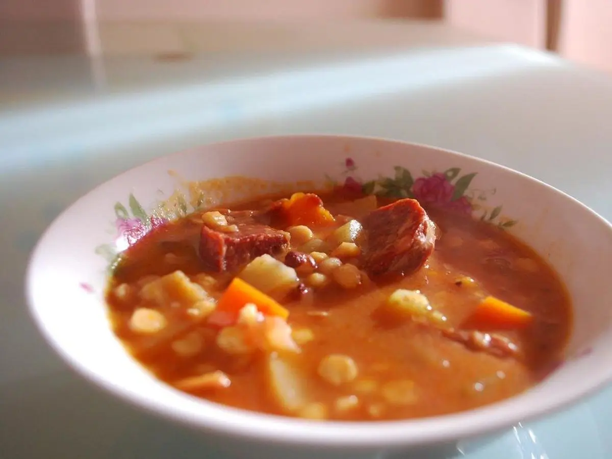 Cazuela de guiso de garbanzos con chorizo y verduras en salsa de tomate