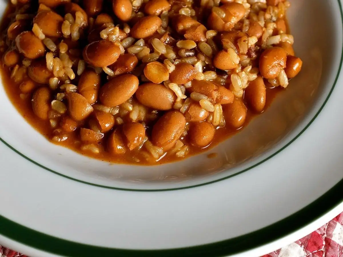 Plato blanco de alubias pintas guisadas en salsa de tomate mezcladas con arroz
