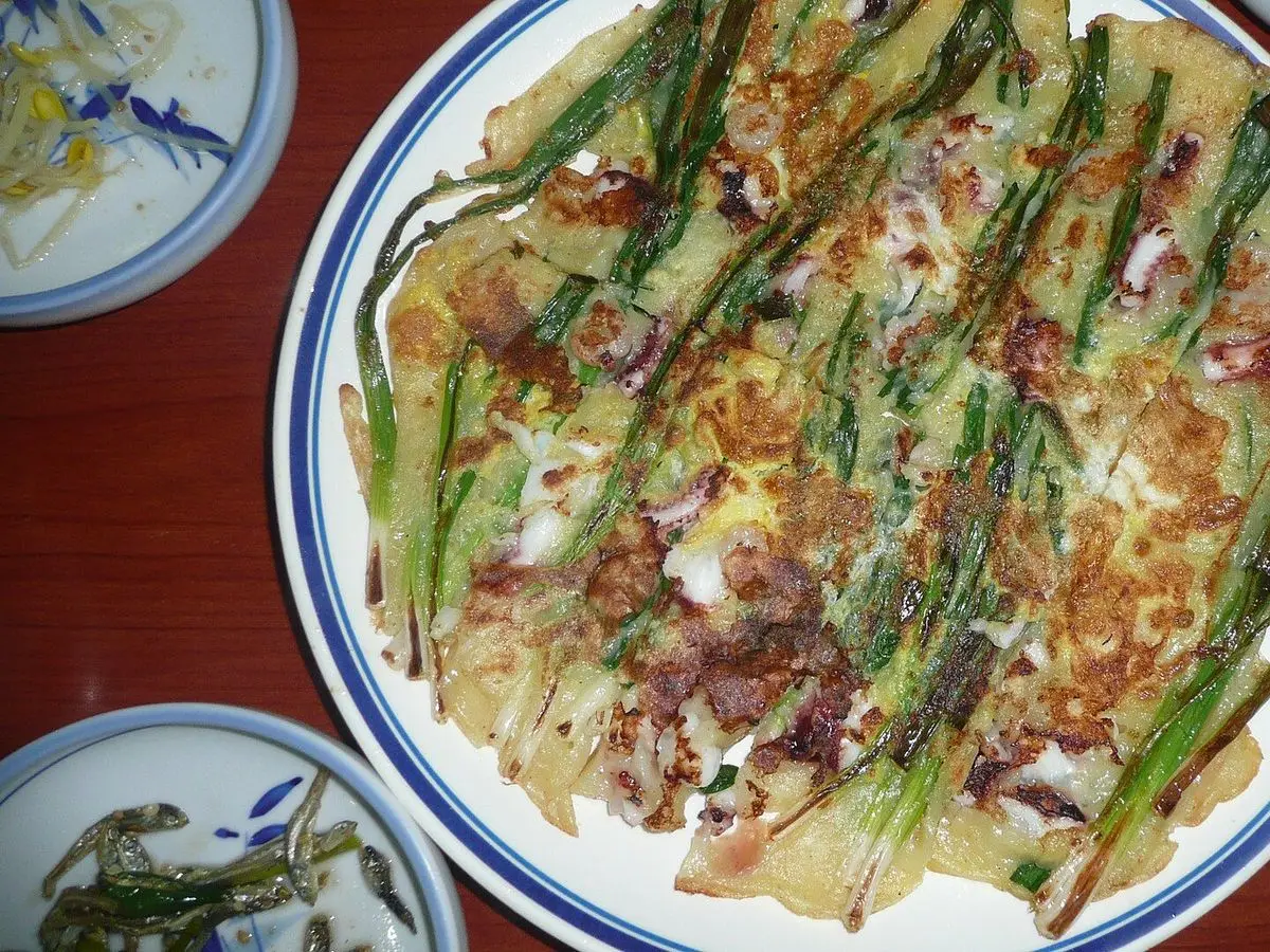 Tortita coreana de cebolleta y marisco en un plato blanco y azul