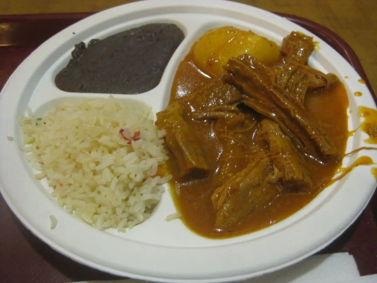 Plato con carne de ternera deshebrada en salsa de tomate, patata, arroz y frijoles negros