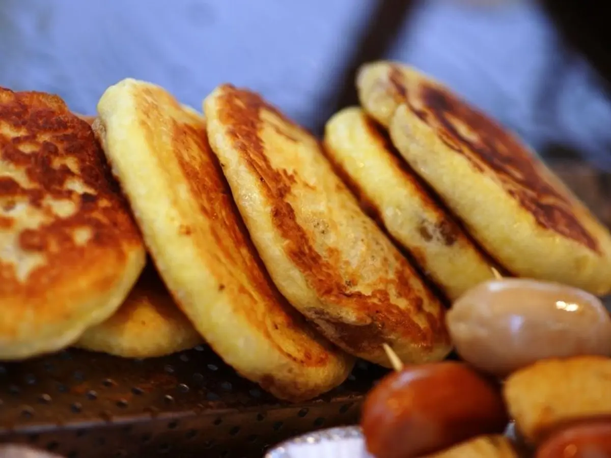 Hotteok, tortitas coreanas doradas y gruesas apiladas, recién hechas en la plancha