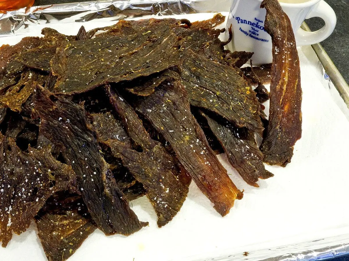 Tiras de cecina de ternera secas y oscuras apiladas sobre papel de aluminio
