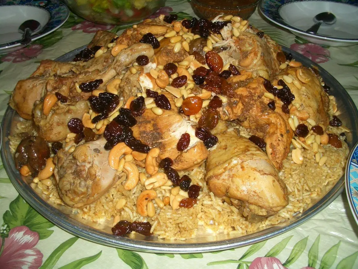 Fuente grande de arroz con pollo, pasas y almendras fileteadas