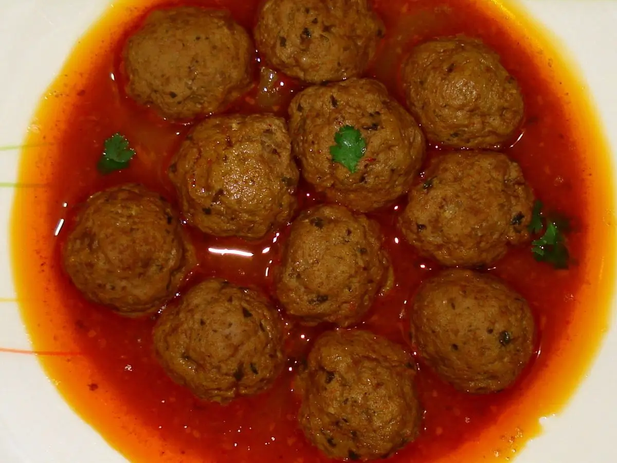 Albóndigas alargadas de carne picada en salsa de tomate roja en un plato