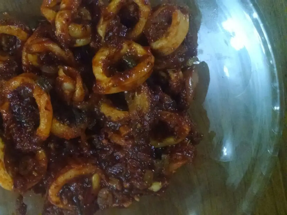 Anillas de calamar guisadas en una salsa espesa y oscura de tomate especiado