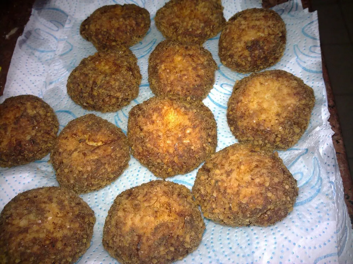 Tortitas sefardíes de puerro y carne fritas y doradas, escurriendo sobre papel de cocina