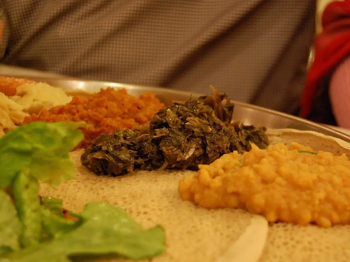 Injera con guisos etíopes de lentejas, guisantes partidos y verduras junto a lechuga