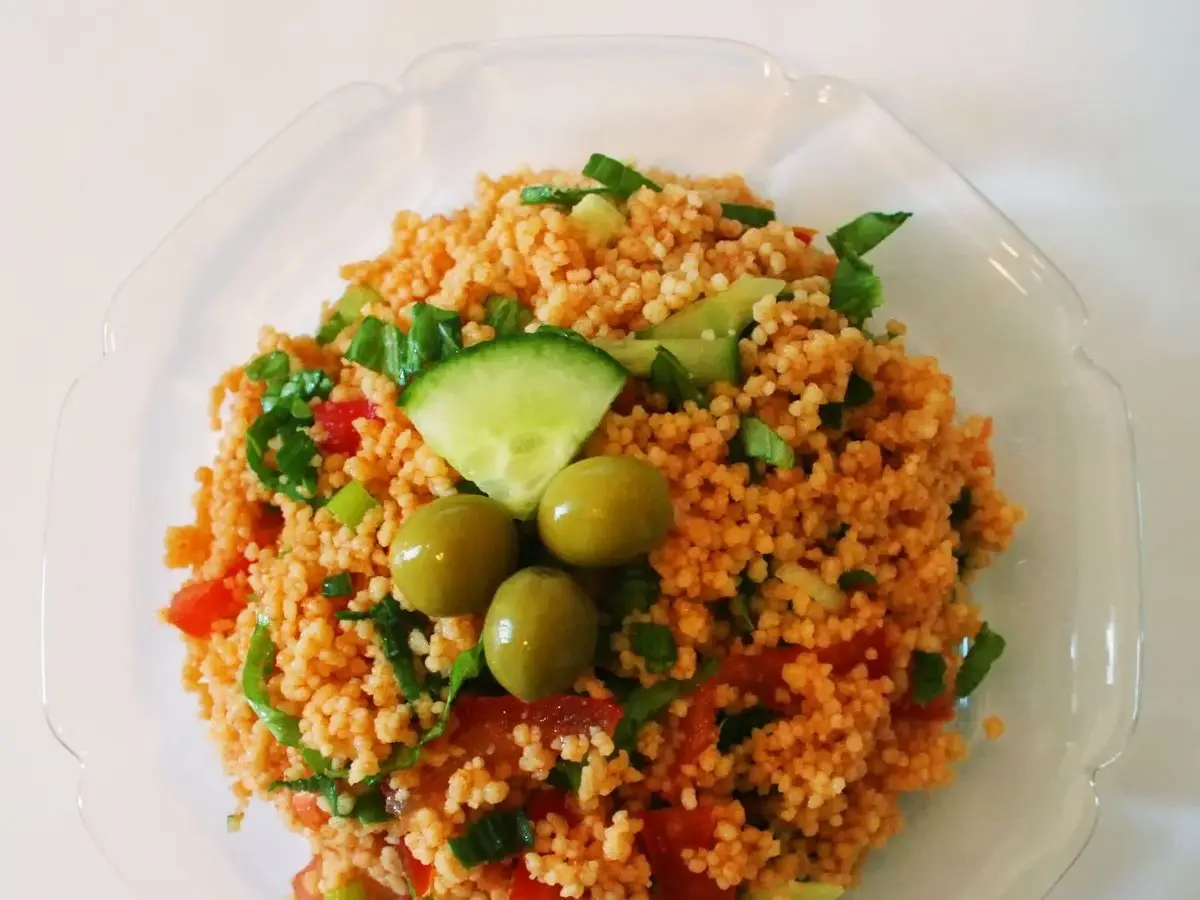 Plato de ensalada turca de bulgur con pepino, aceitunas verdes, tomate y perejil