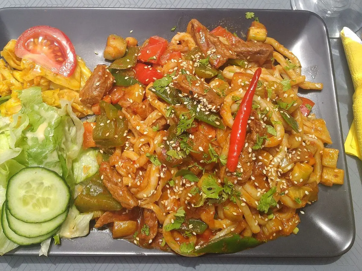 Bandeja con tallarines salteados con pimientos, sésamo y ensalada de pepino y lechuga