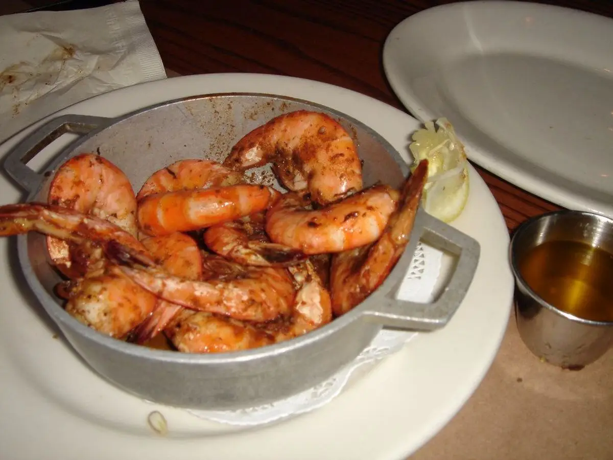 Langostinos cocidos con especias en una cacerola metálica sobre un plato