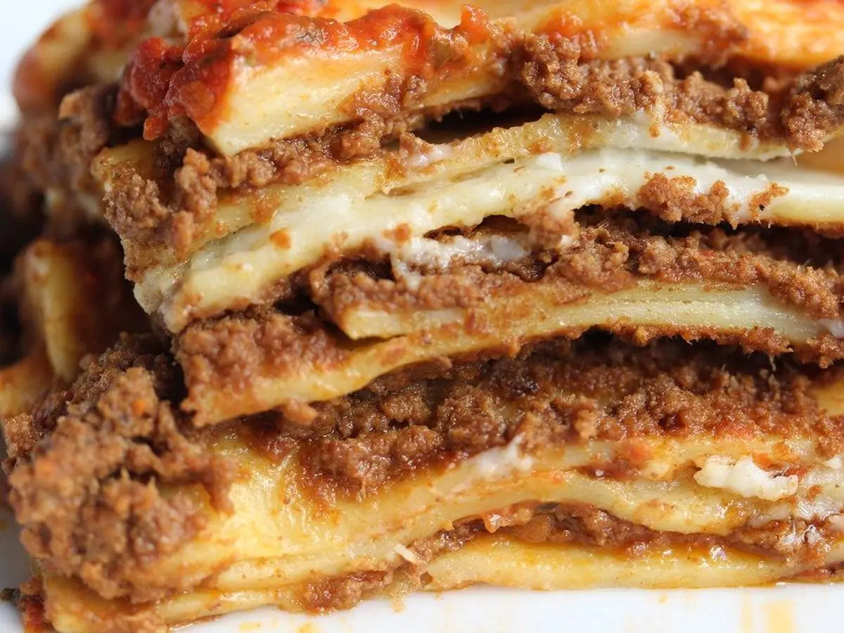 Ración de lasaña con capas de carne y pasta cortada en corte vertical