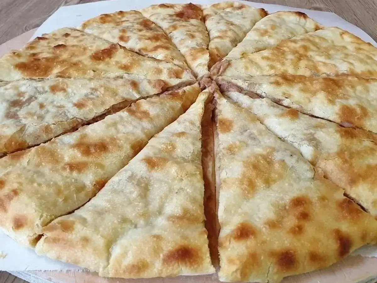 Pan georgiano redondo cortado en porciones triangulares con relleno
