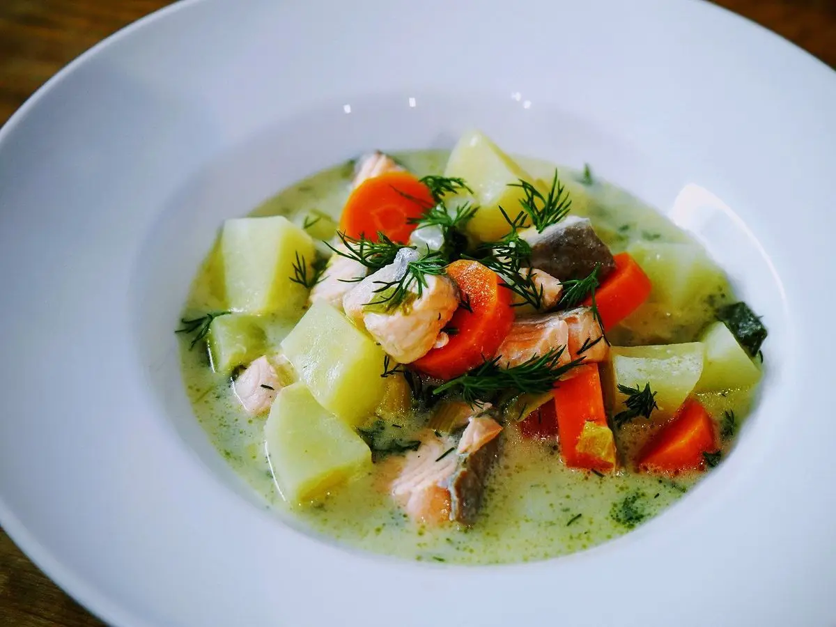 Plato hondo de sopa de salmón con patata, zanahoria, puerro y eneldo