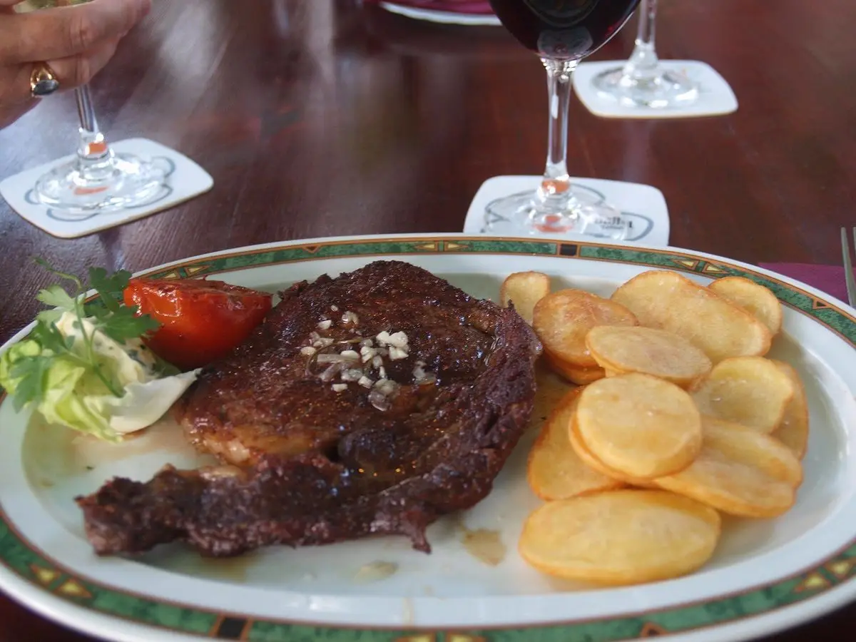 Filete de ternera a la plancha con patatas panaderas en rodajas, tomate y ensalada