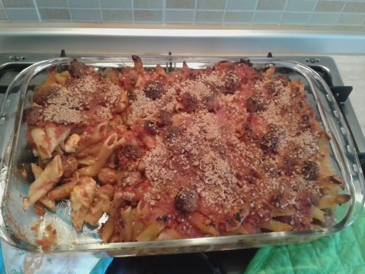 Fuente de cristal con pasta corta gratinada en salsa de tomate y carne