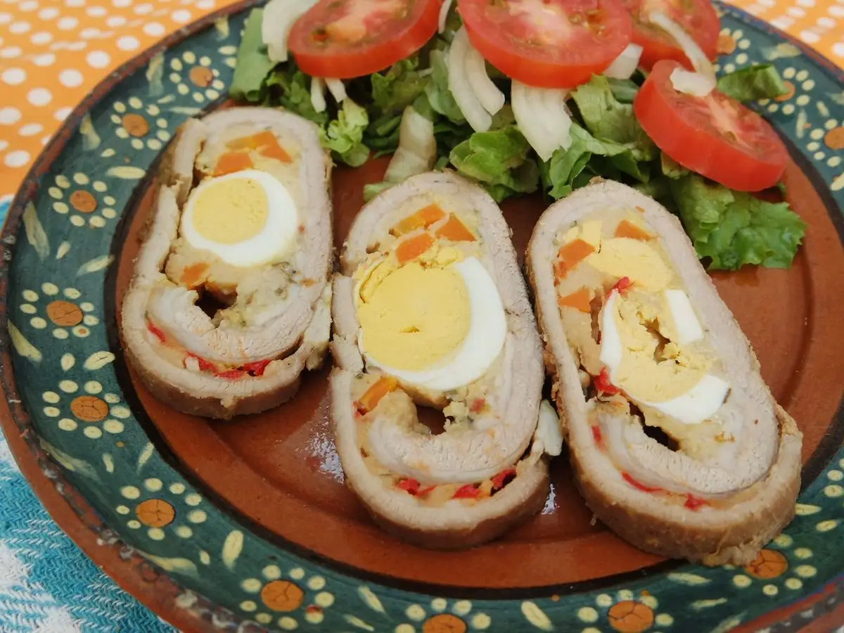 Rodajas de matambre arrollado relleno de huevo duro y zanahoria con ensalada de lechuga y tomate