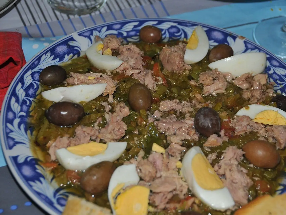 Fuente decorada con ensalada de verduras asadas, atún, huevo duro en cuñas y aceitunas