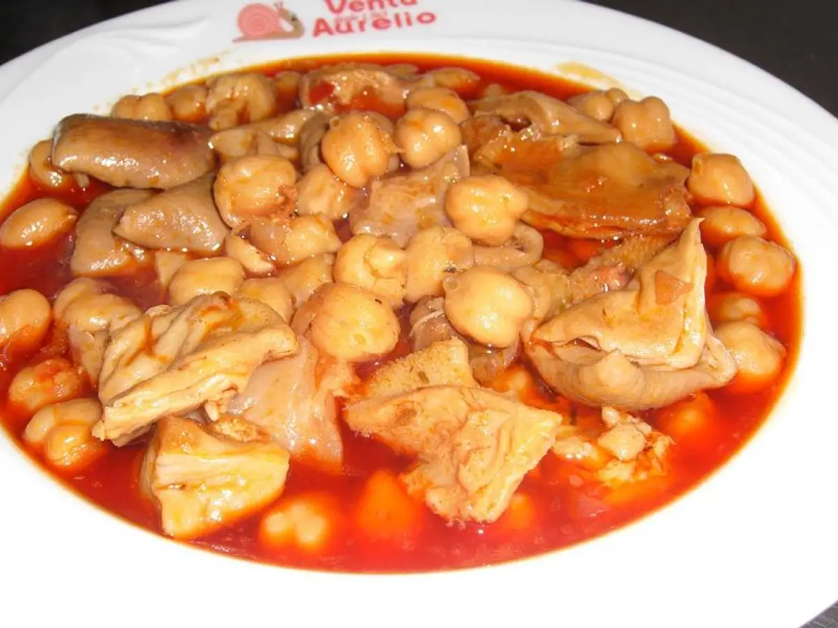 Plato blanco de callos con garbanzos en salsa roja de tomate
