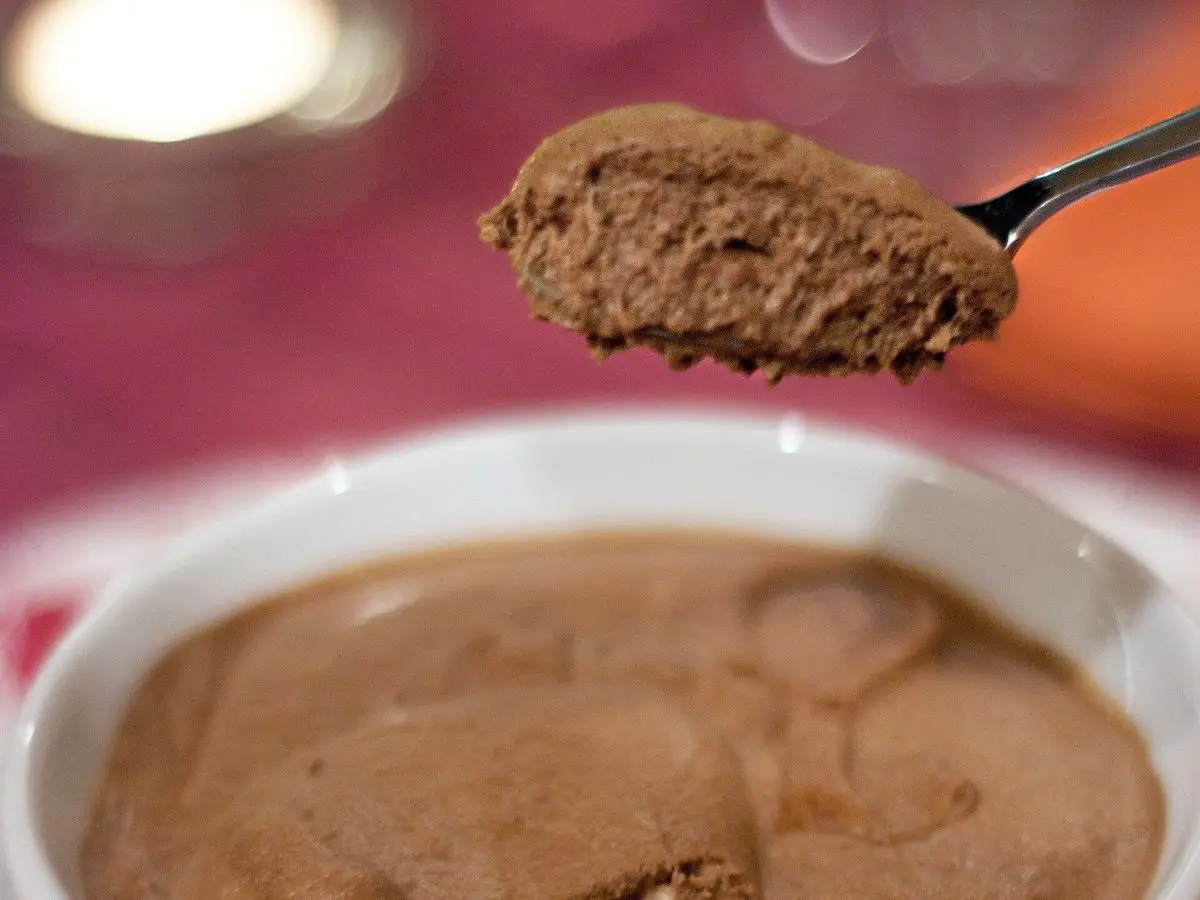 Cuenco blanco con mousse de chocolate cremosa y aireada