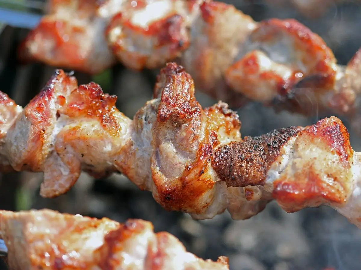 Brochetas de trozos de cerdo asadas a la parrilla, doradas y jugosas
