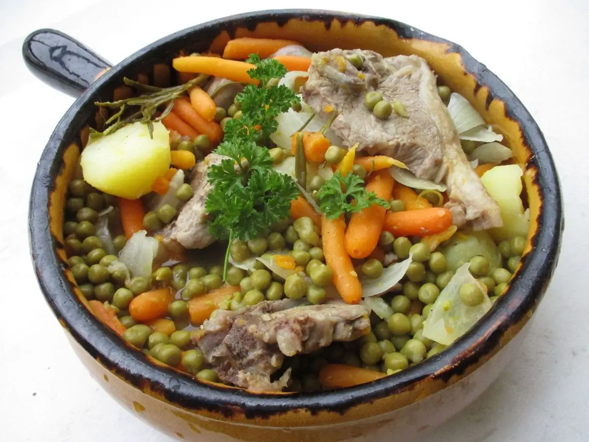 Cazuela de cordero guisado con guisantes, zanahoria, patata y nabo con perejil
