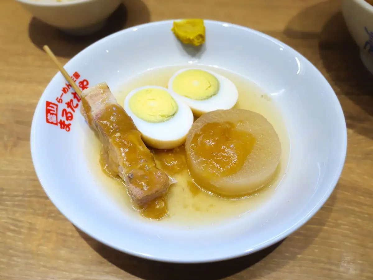 Plato con huevo cocido, rodaja de daikon y brocheta de oden en caldo claro