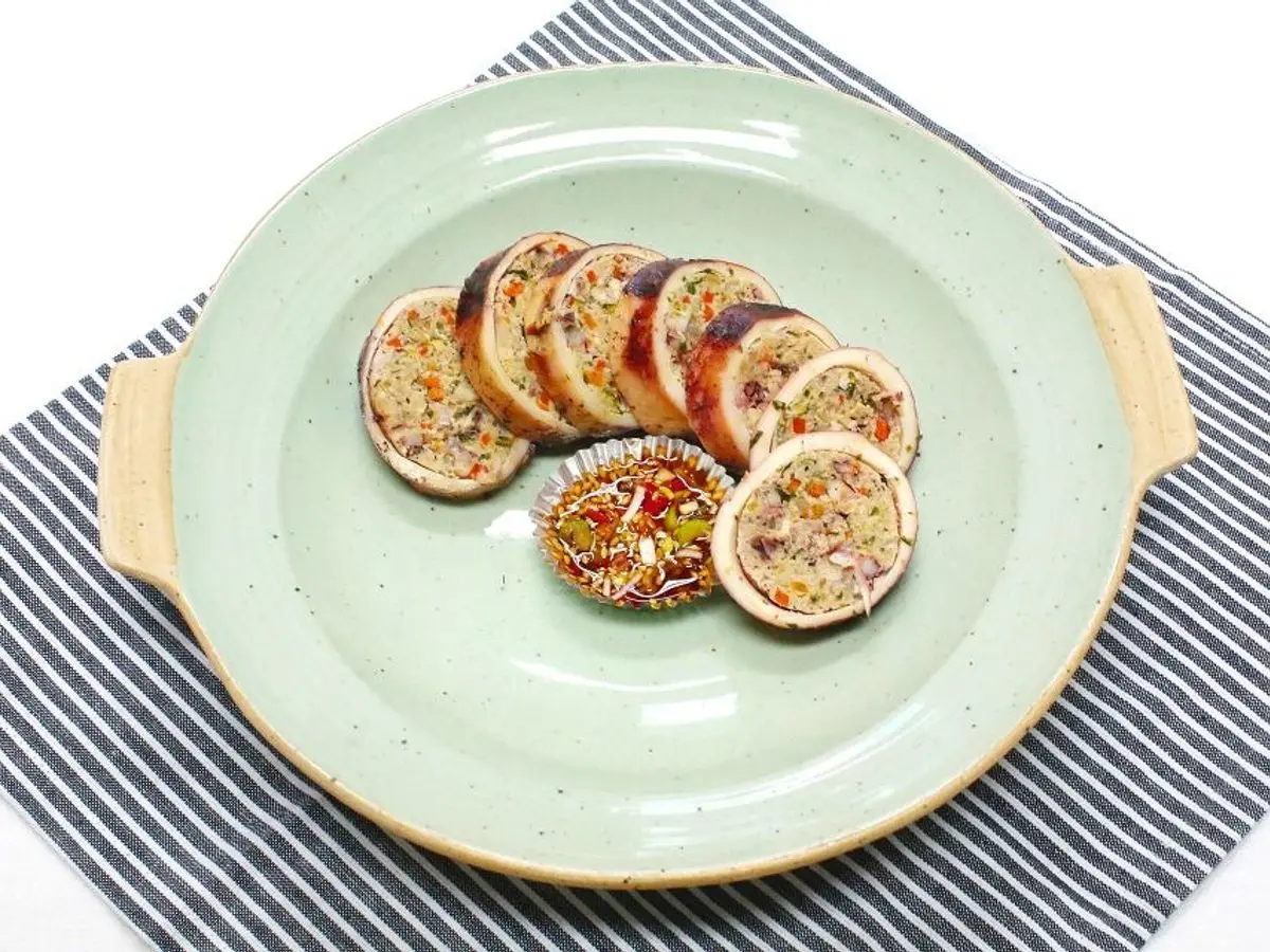 Rodajas de calamar relleno coreano dispuestas en círculo sobre un plato verde claro