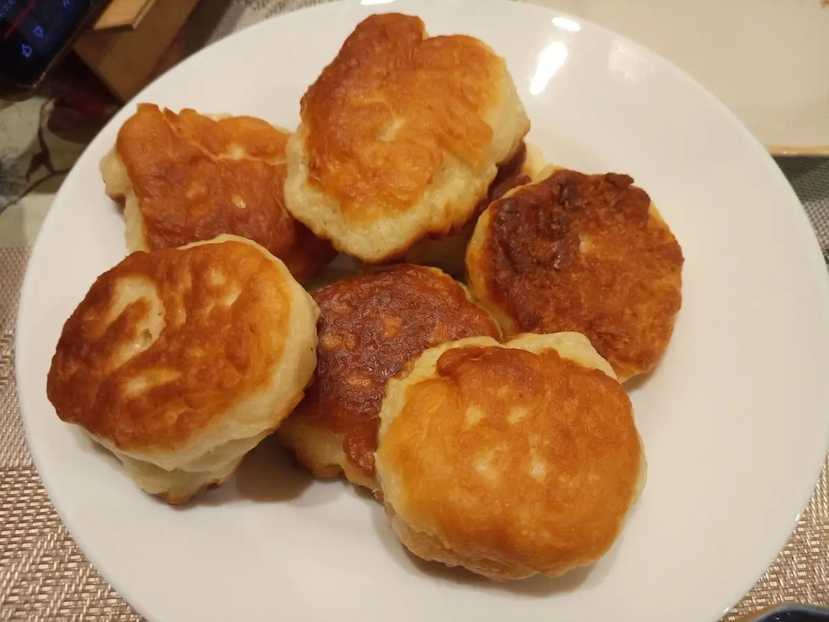 Montón de tortitas gruesas doradas y esponjosas en un plato blanco