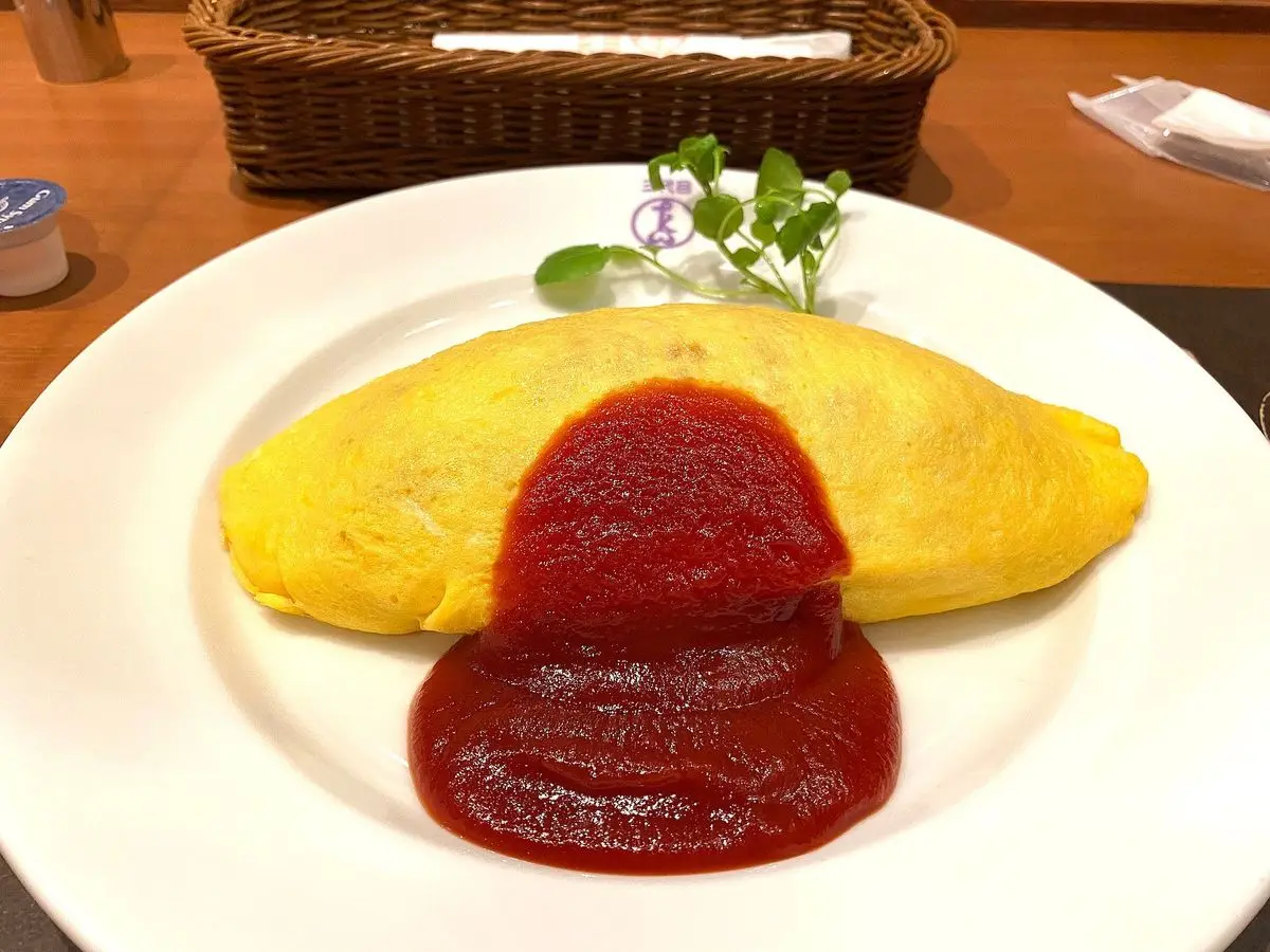 Tortilla francesa amarilla con salsa de tomate roja sobre un plato blanco