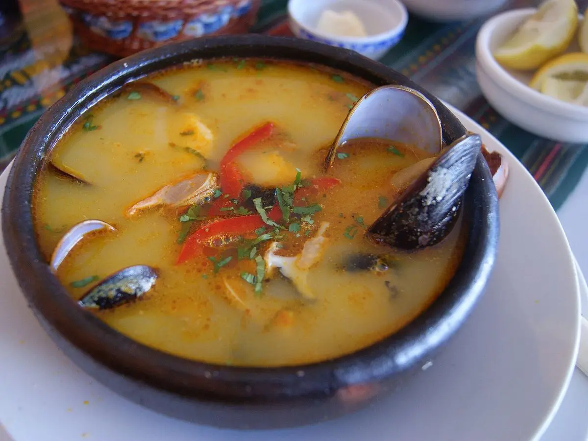 Paila de barro con caldo de pescado y marisco, mejillones, pimiento rojo y trozos de pescado