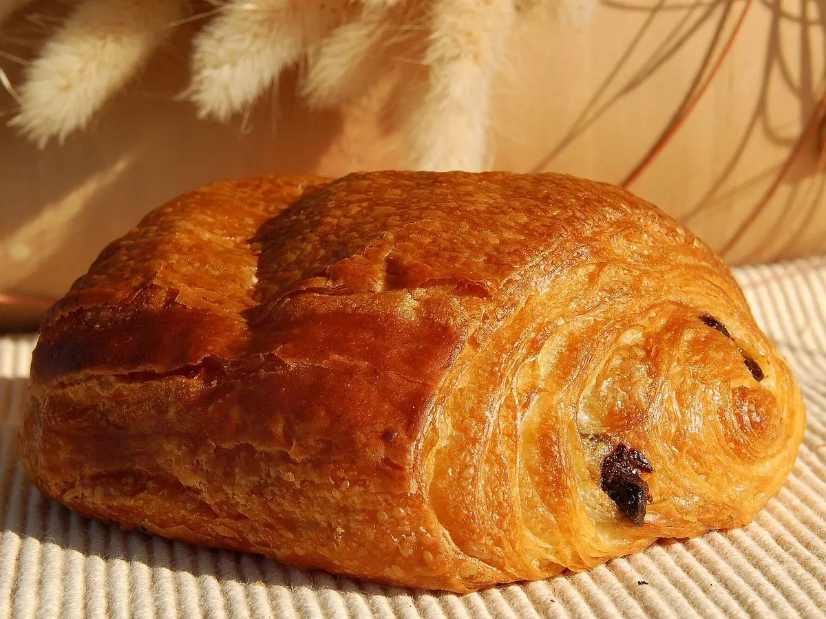 Bollo de hojaldre relleno de chocolate sobre un mantel de fibras claras