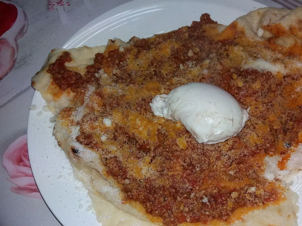 Pane frattau con pan carasau, salsa de tomate, queso rallado y un huevo poché encima
